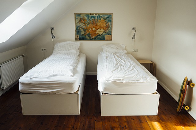 Spálňa v podkroví s dvoma posteľami, na ktorých sú hrubé matrace.jpg